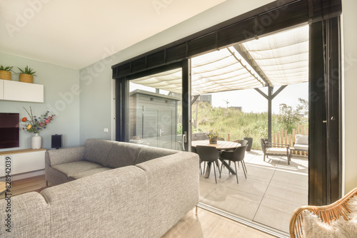 Modern living room opening to a shaded patio area