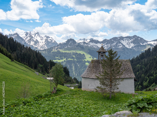 Faschina, Österreich: Die Alpen ragen hinter einer kleinen Kapelle auf