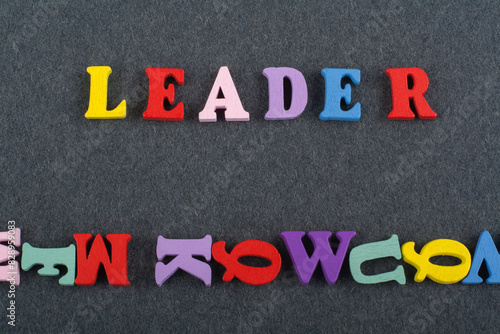 LEADER word on black board background composed from colorful abc alphabet block wooden letters, copy space for ad text. Learning english concept. photo