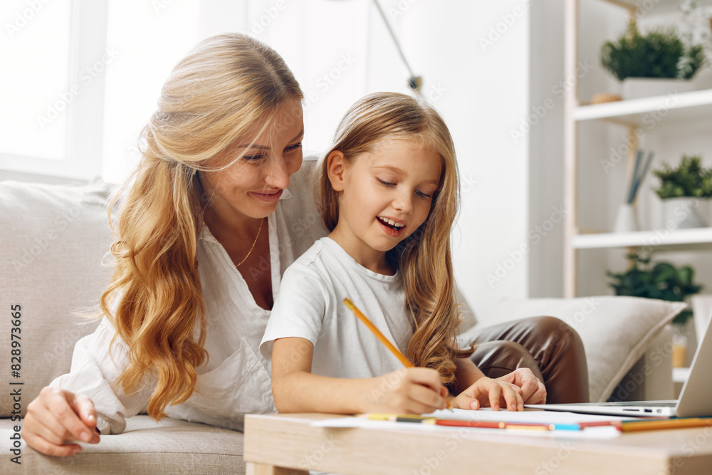 Mother and daughter bonding time on the couch while working together on a laptop in a cozy living room Mother and daughter bonding time on the couch while working together on a laptop in a cozy living room