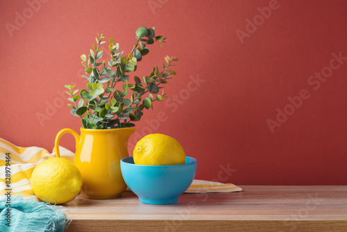 Summer background with lemons and vase on wooden table.