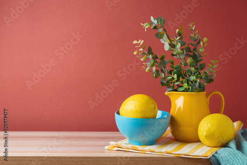 Summer background with lemons and vase on wooden table.