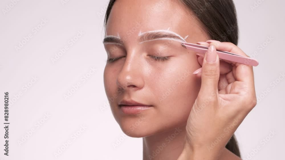 Makeup artist plucks eyebrows in a beauty salon. Professional makeup and cosmetology skin care. Makeup artist plucks eyebrows in a beauty salon. Professional makeup and cosmetology skin care.