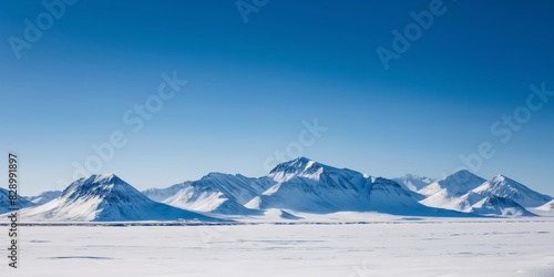 A serene and untouched snowy mountain landscape under a clear blue sky, representing a cold but beautiful winter
