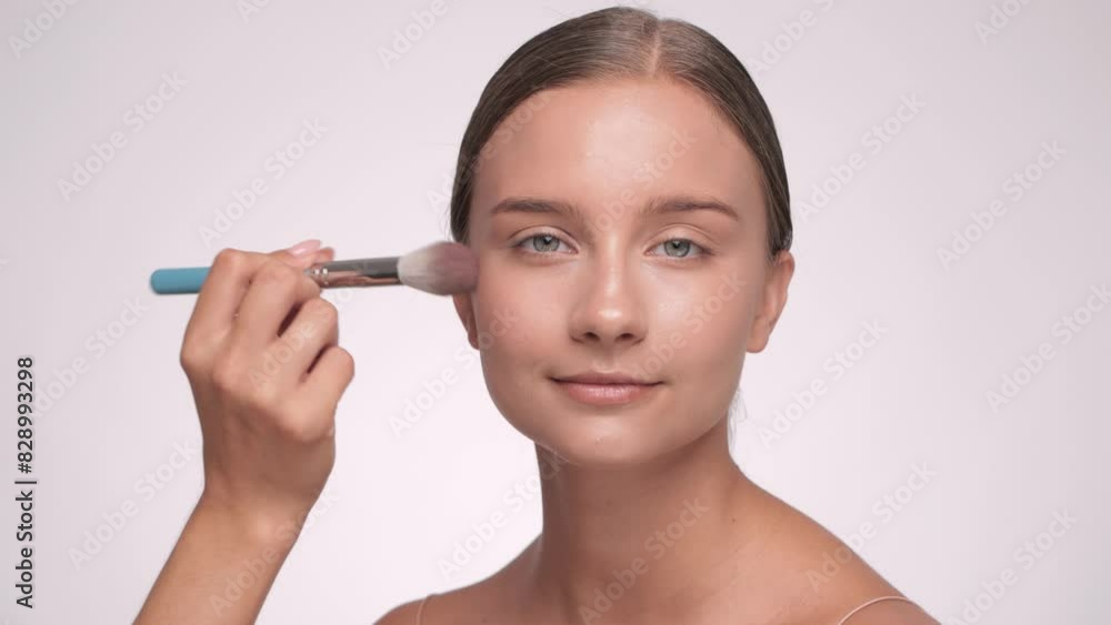 Makeup artist applies blush to the face. Portrait of a beautiful brunette girl with beautiful fresh makeup and healthy clean skin. Professional makeup concept Makeup artist applies blush to the face. Portrait of a beautiful brunette girl with beautiful fresh makeup and healthy clean skin. Professional makeup concept
