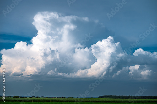 A huge storm cloud with a wall of rain in the countryside.	
