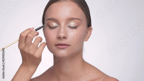 Makeup artist applies eye shadow.The concept of aesthetic cosmetology and makeup.