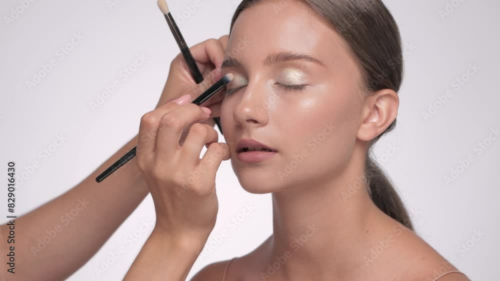 Makeup artist applies eye shadow.The concept of aesthetic cosmetology and makeup. Makeup artist applies eye shadow.The concept of aesthetic cosmetology and makeup.