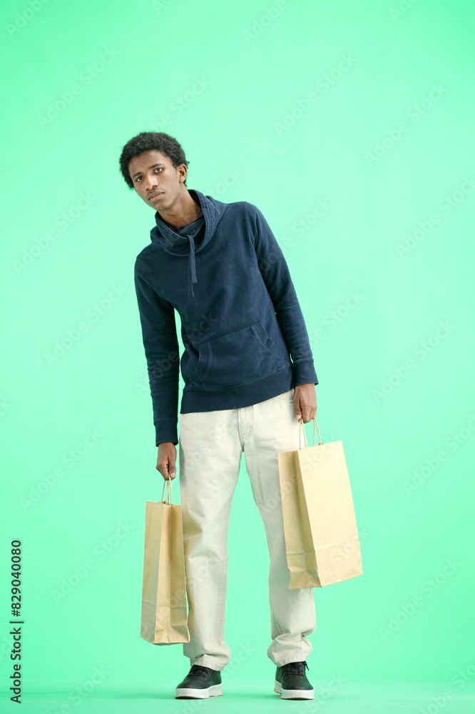 A man, full-length, on a green background, with bags A man, full-length, on a green background, with bags