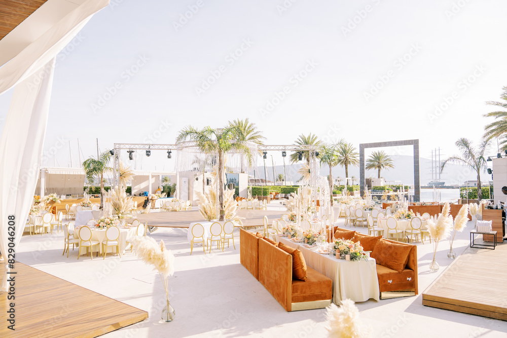 Festive tables stand around a stage on the open sunny terrace