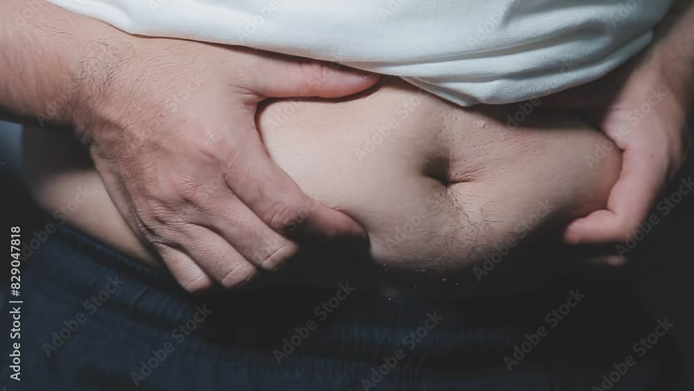 Man pointing own unhealthy big belly with visceral or subcutaneous fats. Pose health risk. Man pointing own unhealthy big belly with visceral or subcutaneous fats. Pose health risk.