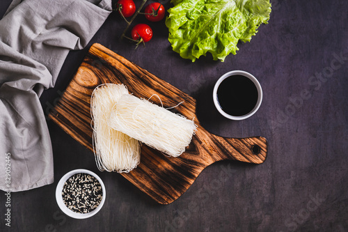 Asian raw rice noodles funchose on a wooden board on the table top view photo