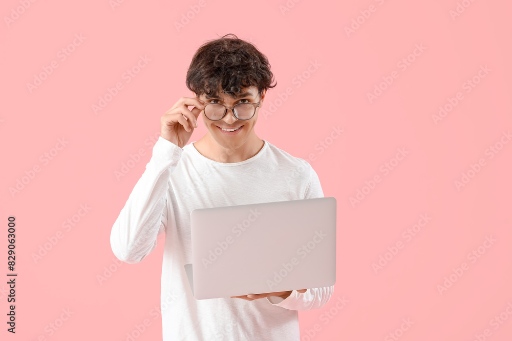 Male programmer with laptop on pink background Male programmer with laptop on pink background