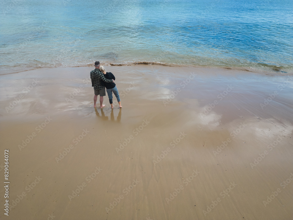 A young couple together on a beach in Portugal on a spring day, photo view from a drone. A young couple together on a beach in Portugal on a spring day, photo view from a drone.