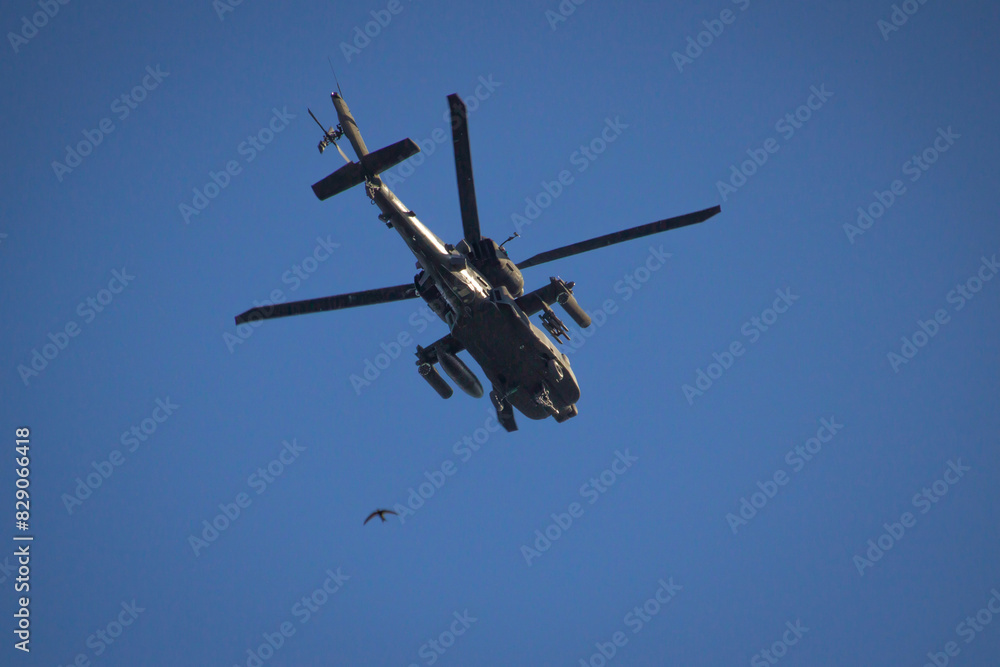 Military helicopter and small bird on a blue sky Military helicopter and small bird on a blue sky