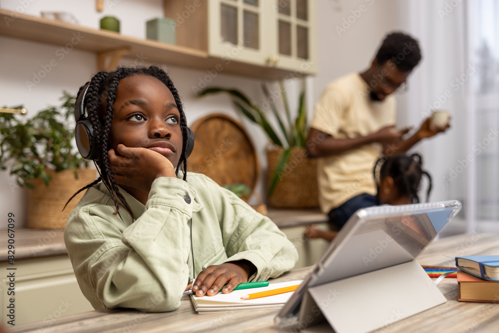 Little girl working on homework assignment using tablet studying at home Little girl working on homework assignment using tablet studying at home