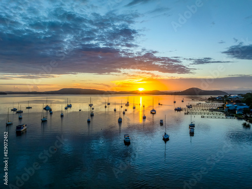 Aerial sunrise waterscape with boats, clouds and reflections