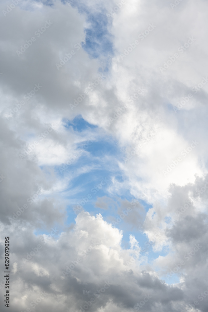 Obraz premium Dramatic sky of medium blue with bright white and gray clouds as a nature background 
