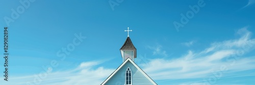 A shot of a traditional church steeple reaching into a clear blue sky symbolizing faith and spirituality photo