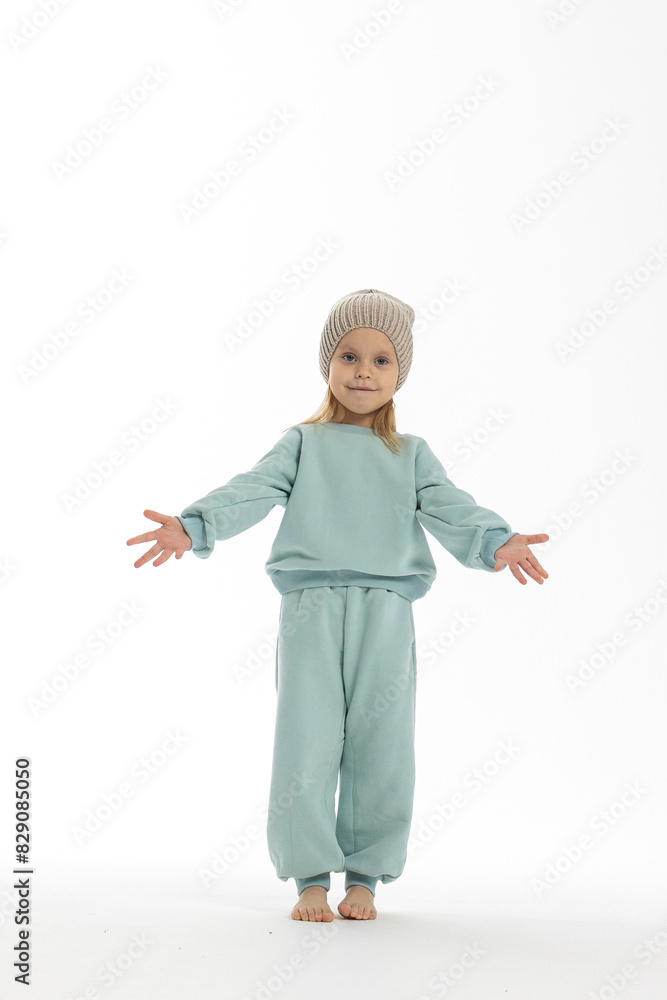 Portrait of beautiful cute little toddler girl. Child with funny face in mint sweatshirt and hat. Pretty smile kid in studio on white background. Portrait of beautiful cute little toddler girl. Child with funny face in mint sweatshirt and hat. Pretty smile kid in studio on white background.