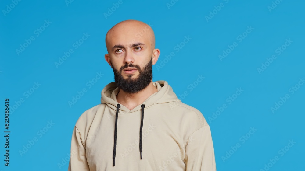 Young guy gesturing no sign over studio background, posing in studio and showing negative emotion. Middle eastern model doing forbidden gesture, expressing his refusal. Camera 2. Handheld shot. Young guy gesturing no sign over studio background, posing in studio and showing negative emotion. Middle eastern model doing forbidden gesture, expressing his refusal. Camera 2. Handheld shot.