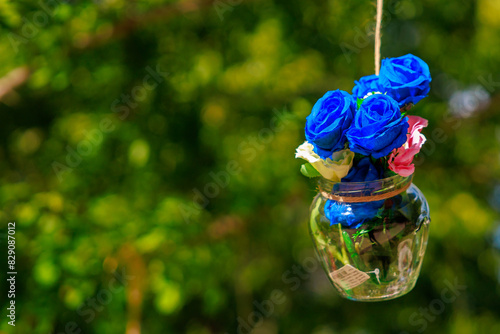 Blue vase with flowers hanging from it