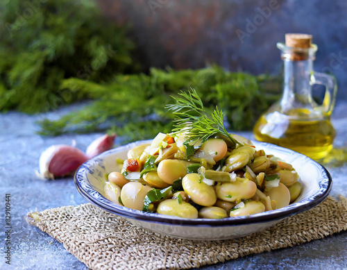 A traditional Turkish appetizer, fresh broad bean salad is prepared with olive oil, broad beans, onion, and dill photo