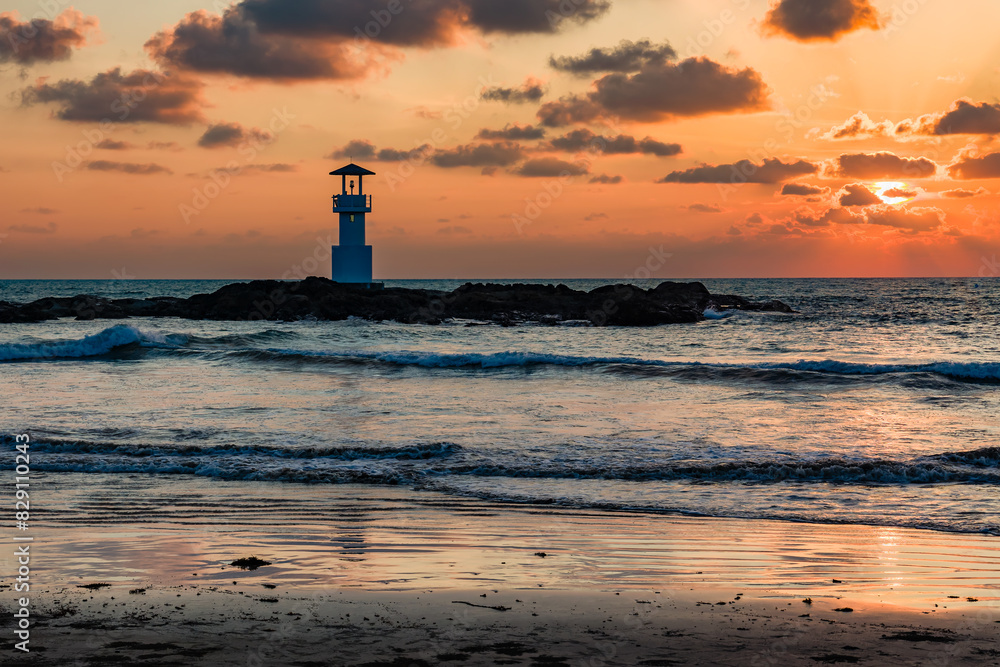 Tropical sunset behind a lighthouse on a warm ocean (Nangthong Beach, Khao Lak, Thailand) Tropical sunset behind a lighthouse on a warm ocean (Nangthong Beach, Khao Lak, Thailand)