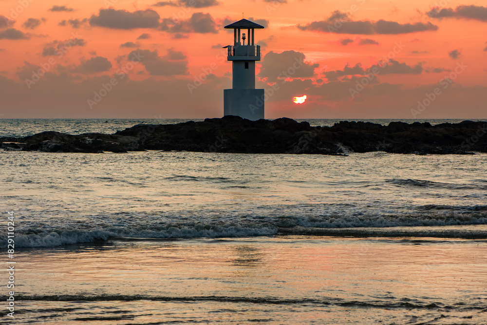 Tropical sunset behind a lighthouse on a warm ocean (Nangthong Beach, Khao Lak, Thailand) Tropical sunset behind a lighthouse on a warm ocean (Nangthong Beach, Khao Lak, Thailand)