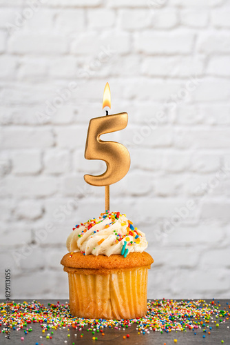 Cupcake with number 5 birthday candle - White block wall background