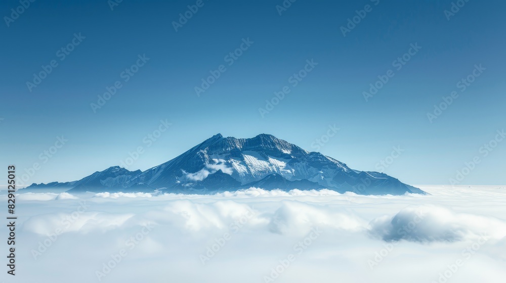 Majestic snow-capped mountain peak rising above the clouds Majestic snow-capped mountain peak rising above the clouds