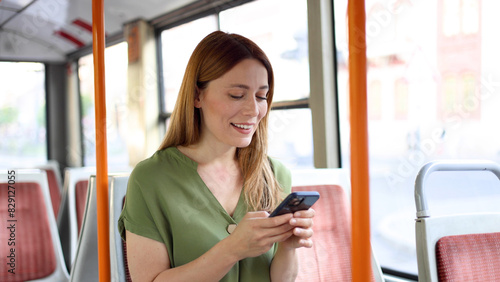 Free Download Happy young woman using smartphone while riding in a bus - GFXLoad
