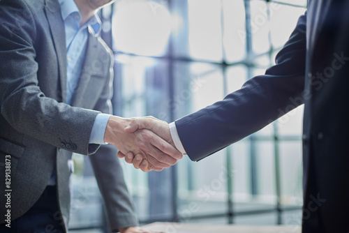 Two diverse professional business men executive leaders shaking hands at office meeting photo