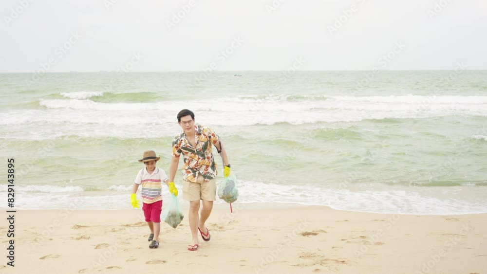 Asian family father and little son picking up plastic trash and garbage together at the beach on summer holiday vacation. Environmental conservation earth day, volunteers and waste pollution concept. Asian family father and little son picking up plastic trash and garbage together at the beach on summer holiday vacation. Environmental conservation earth day, volunteers and waste pollution concept.