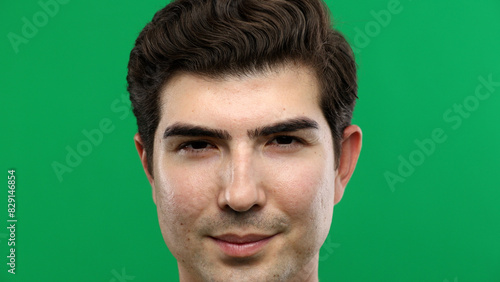 Man's face, close-up, on a green background