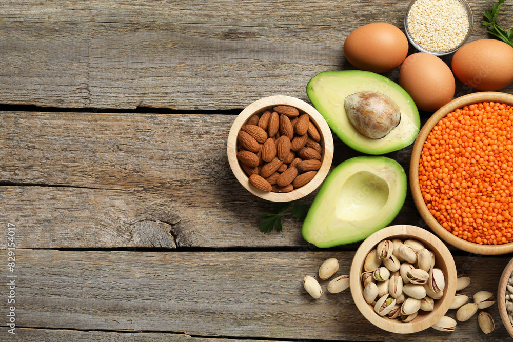 Different products high in natural fats on wooden table, flat lay. Space for text Different products high in natural fats on wooden table, flat lay. Space for text