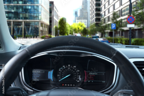 Dashboard with speedometer behind steering wheel inside car © New Africa