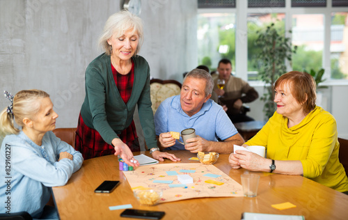 Older men and women playing board game together