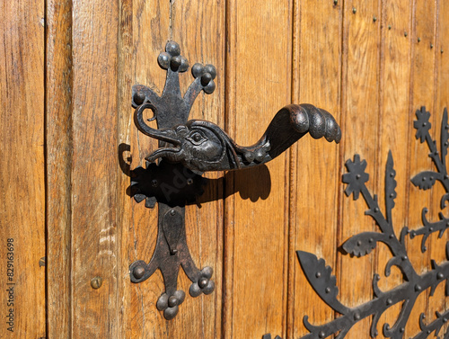 Retro vintage door handle close up. Old wooden door with beautiful retro door knobs in the shape of a ducks head and wing. Selective focus.