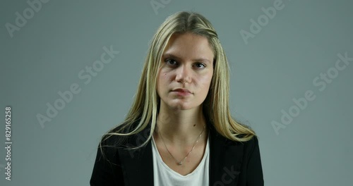 Neutral background, serious woman listens intently
