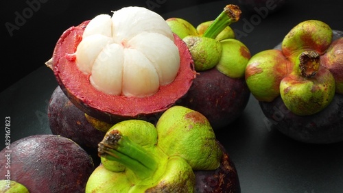 Behold the magnificence of a mangosteen, its robust purple rind embraces segments of pristine white flesh. This close-up exudes exotic allure and promises a tantalizing sensory experience.
