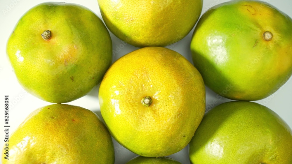 A cluster of vibrant green oranges, snugly nestled, their glossy skins gleaming under the light. Their hue hints at ripeness, promising a burst of tangy sweetness soon. Orange fruit background.
A cluster of vibrant green oranges, snugly nestled, their glossy skins gleaming under the light. Their hue hints at ripeness, promising a burst of tangy sweetness soon. Orange fruit background.