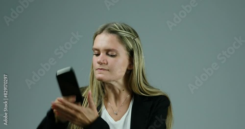 Woman frustratedly tugs phone, shows comic aggression