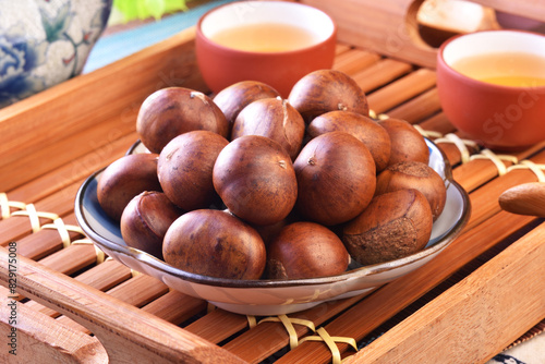 Roasted chestnuts on the plate served with Chinese tea. 