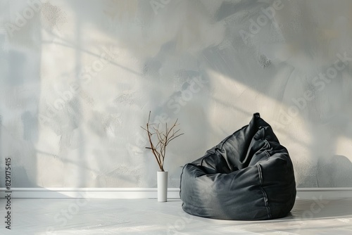 Black bean bag chair near light grey wall Room for writing photo