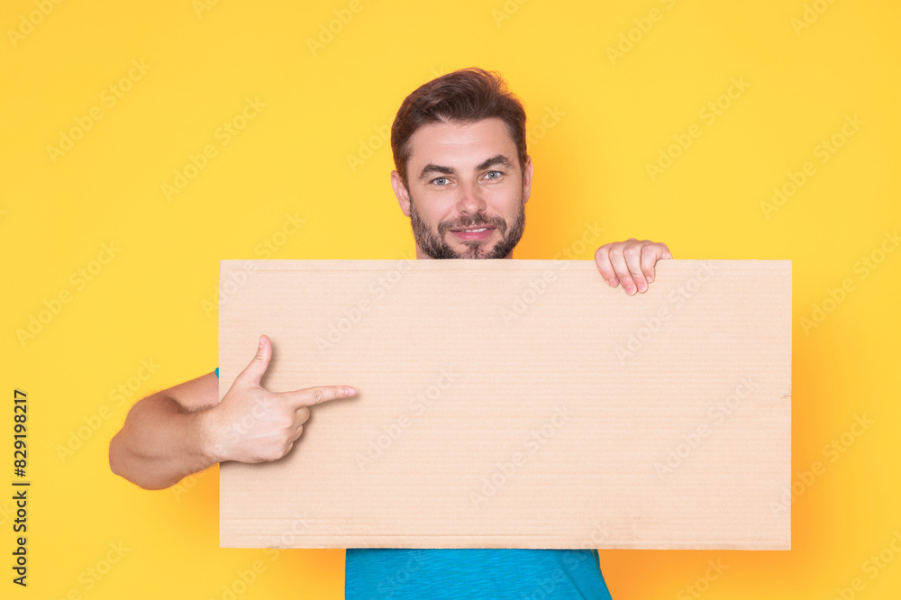 Handsome middle aged man with blank placard. Demonstrating copy space for your text or design. Man showing empty advertisement board on studio background. Blank placard, signboard for ad. Handsome middle aged man with blank placard. Demonstrating copy space for your text or design. Man showing empty advertisement board on studio background. Blank placard, signboard for ad.