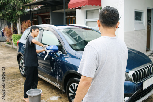 Rearview of Father Told Son To Wipe The Car In Garage. Son Helping Father Washing Car.  © Queenmoonlite Studio