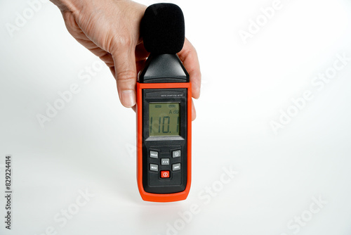 Pollution is too loud.hand holding a digital sound level on a white background,Sound level meters are commonly used in noise pollution studies.