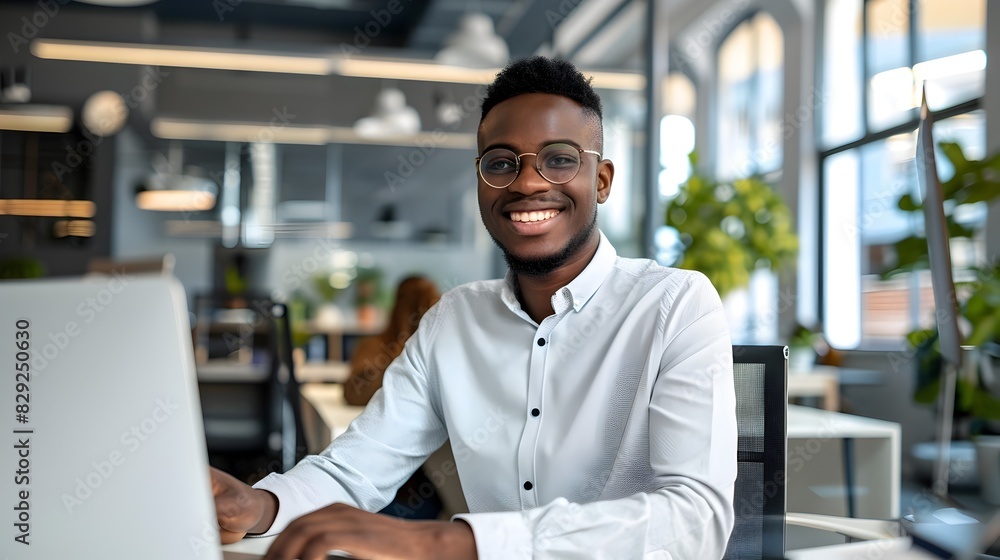 Confident Young Chief Technology Officer Working Happily at Office Desk with Laptop Confident Young Chief Technology Officer Working Happily at Office Desk with Laptop