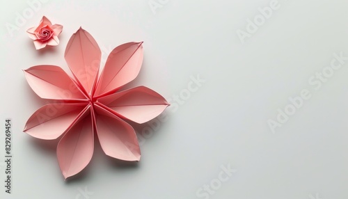 Pink origami flower on white background